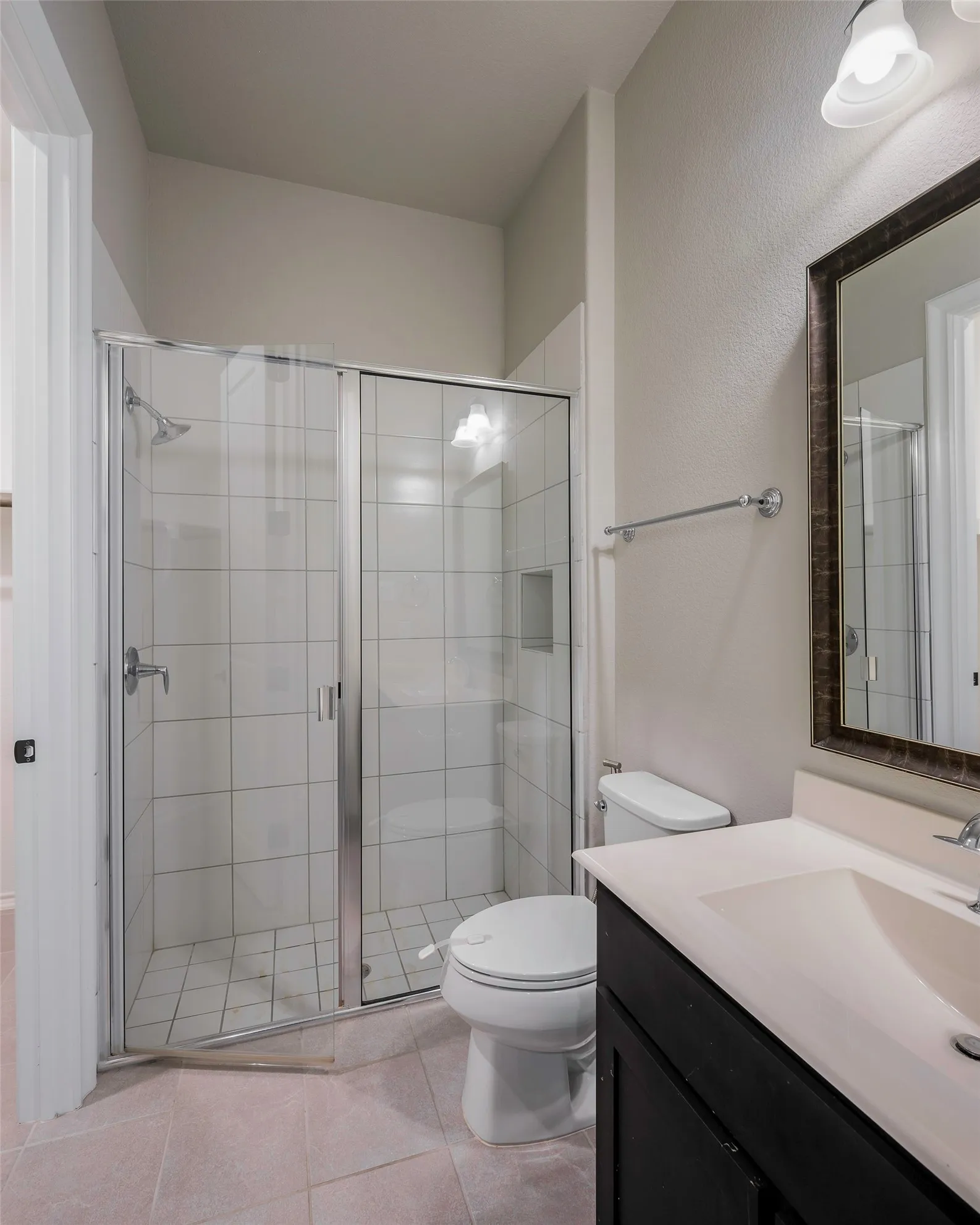 Glass-enclosed shower with white square-tiled walls