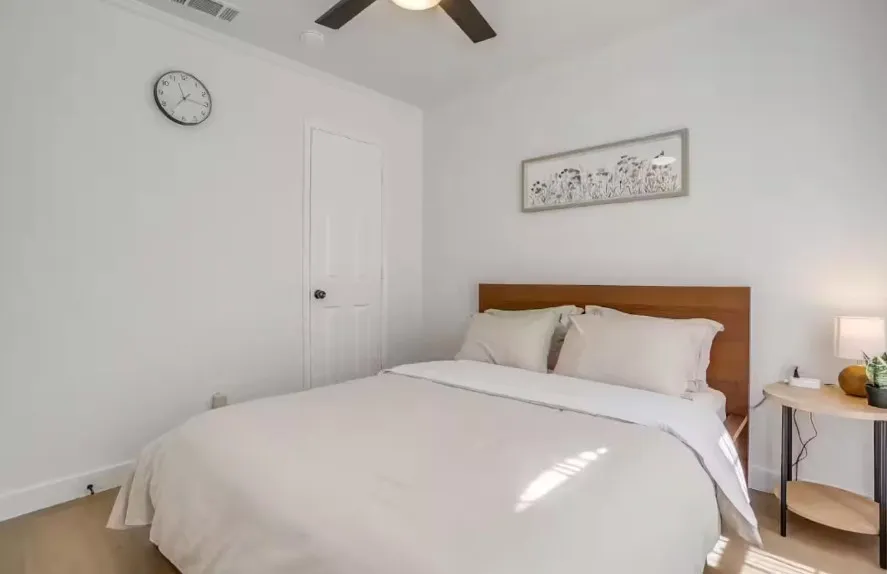 Wood-finish flooring, ceiling fan, and white painted walls