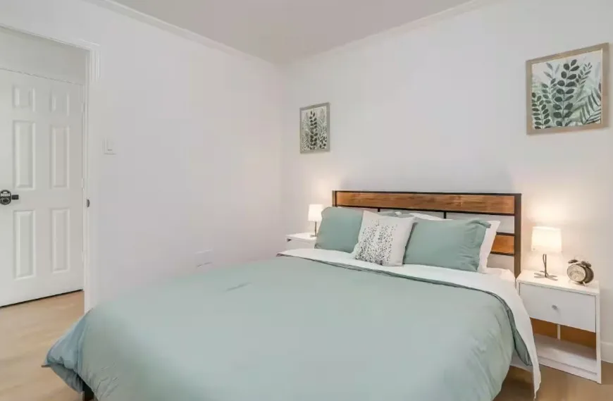 Wood-finish flooring with white walls and a white paneled door