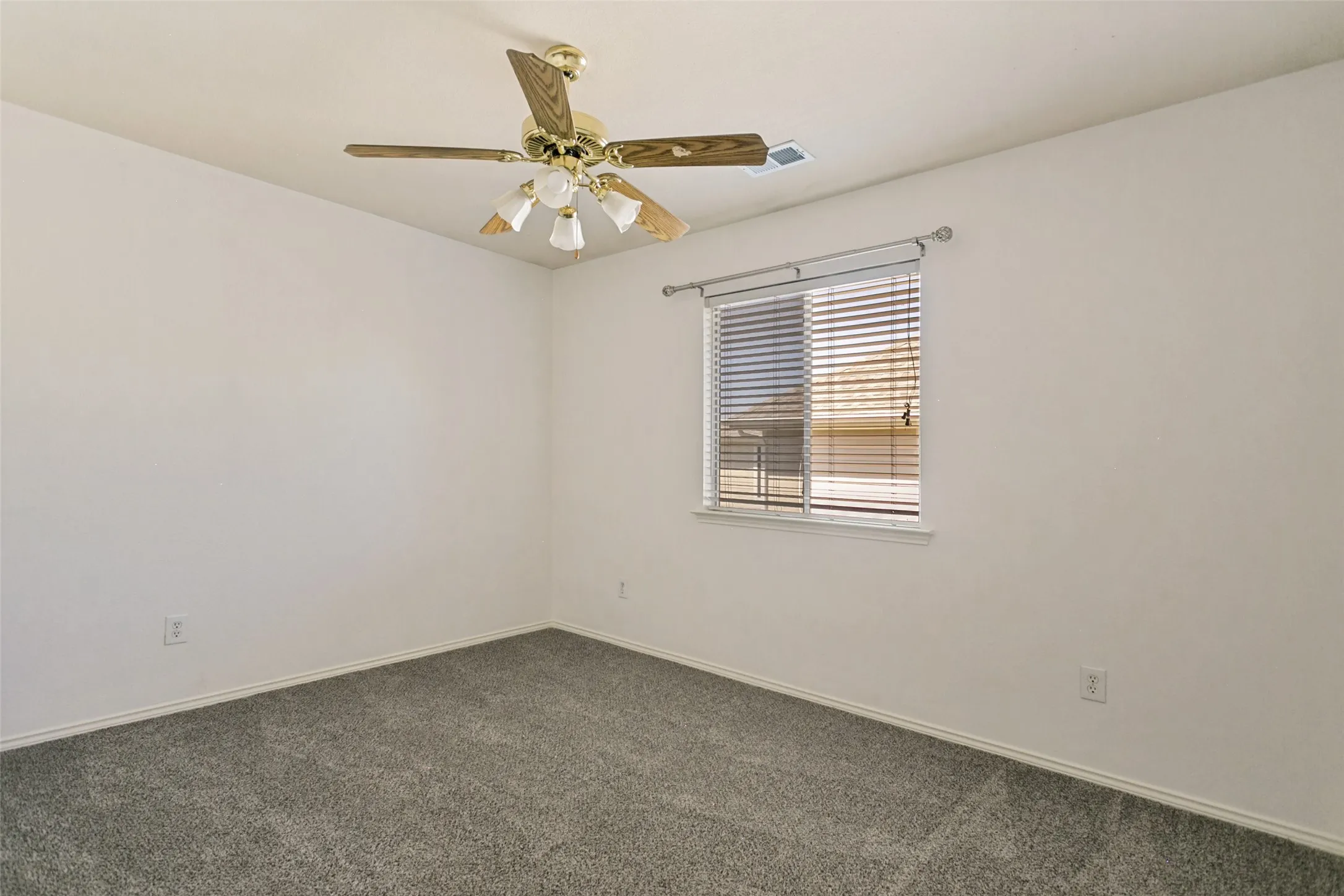 Window with blinds, ceiling fan with integrated lighting, and wall-to-wall carpeting
