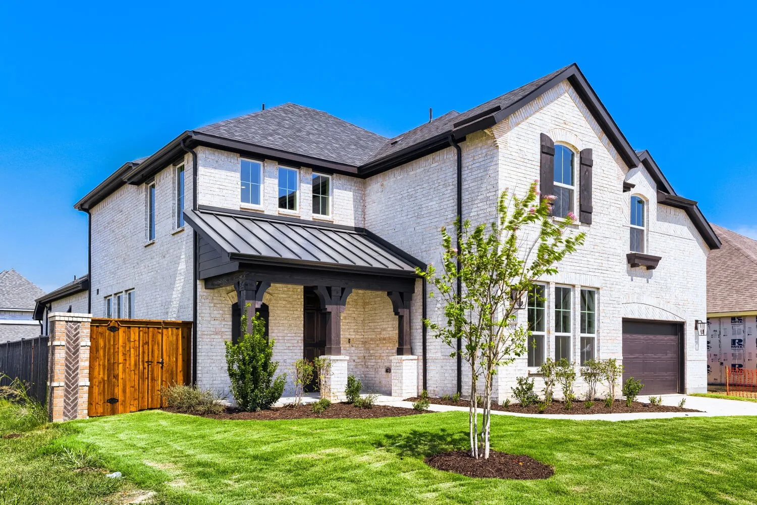White brick exterior with dark trim and shutters