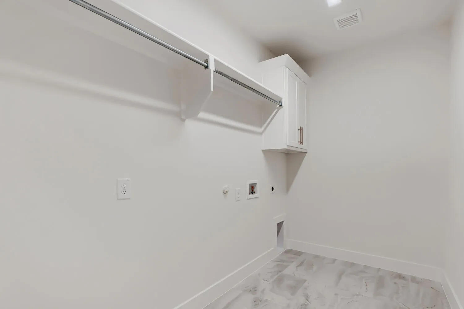 White walls, built-in shelving, hanging rod, white cabinetry, and tile flooring