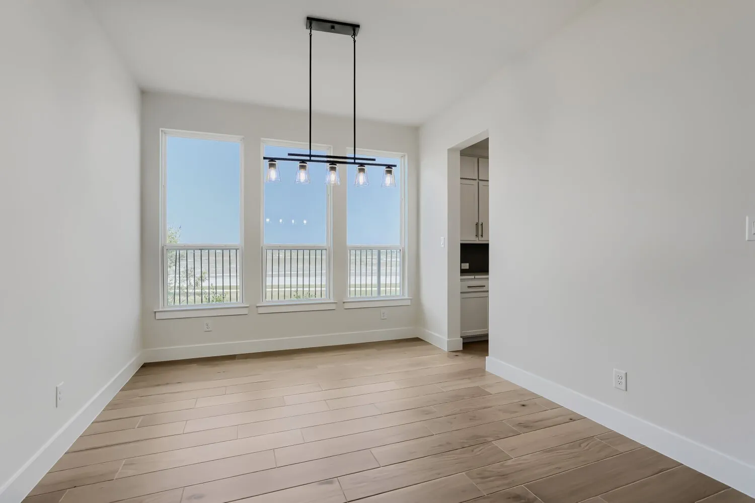 Dining area with wood floors and modern light fixture