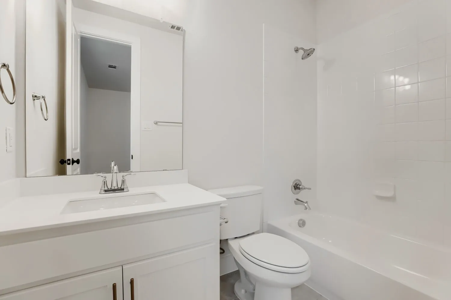 White vanity with a single sink, chrome faucet, and white countertop