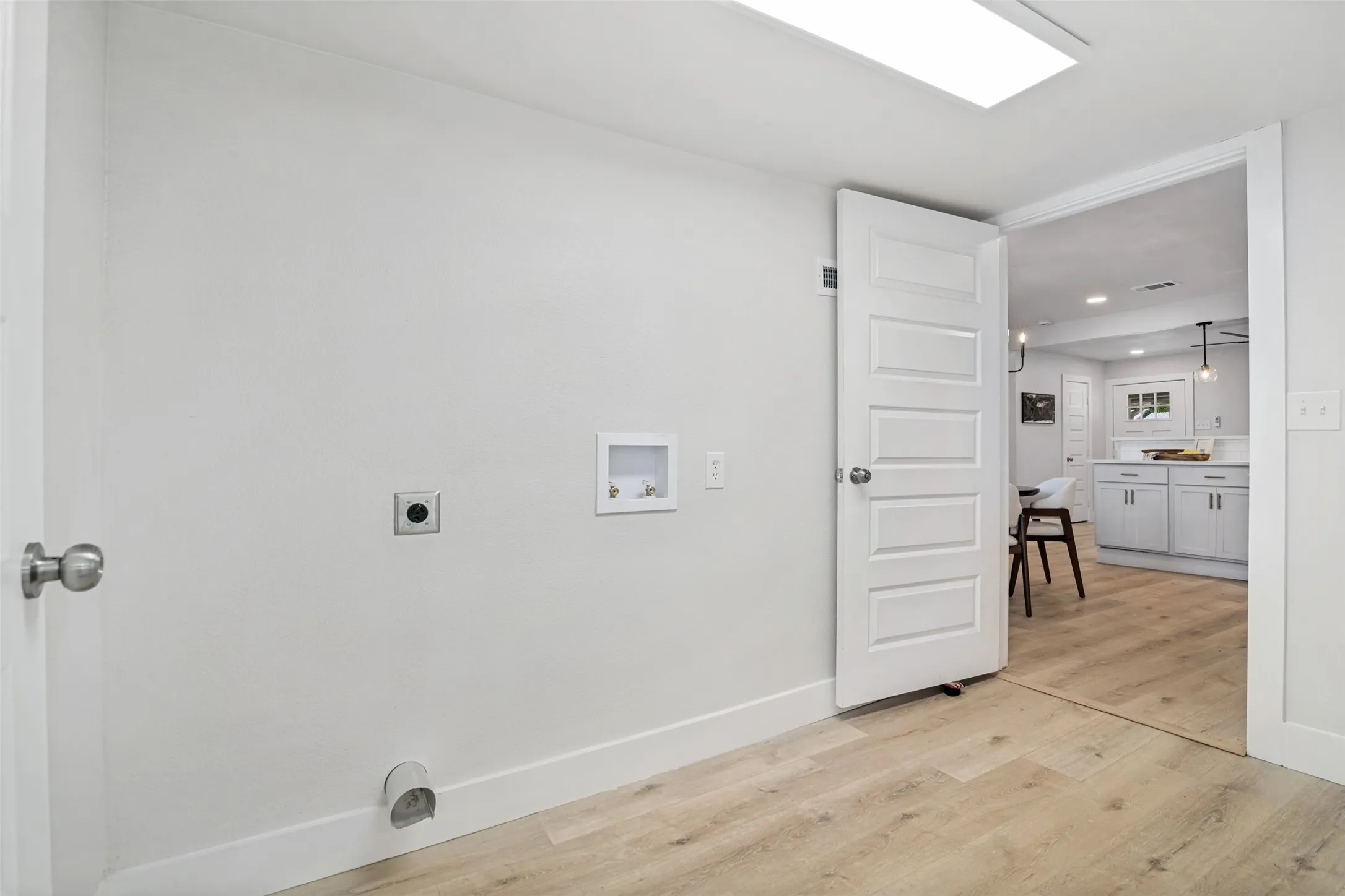 Light wood-finish flooring, recessed ceiling lighting, and white walls