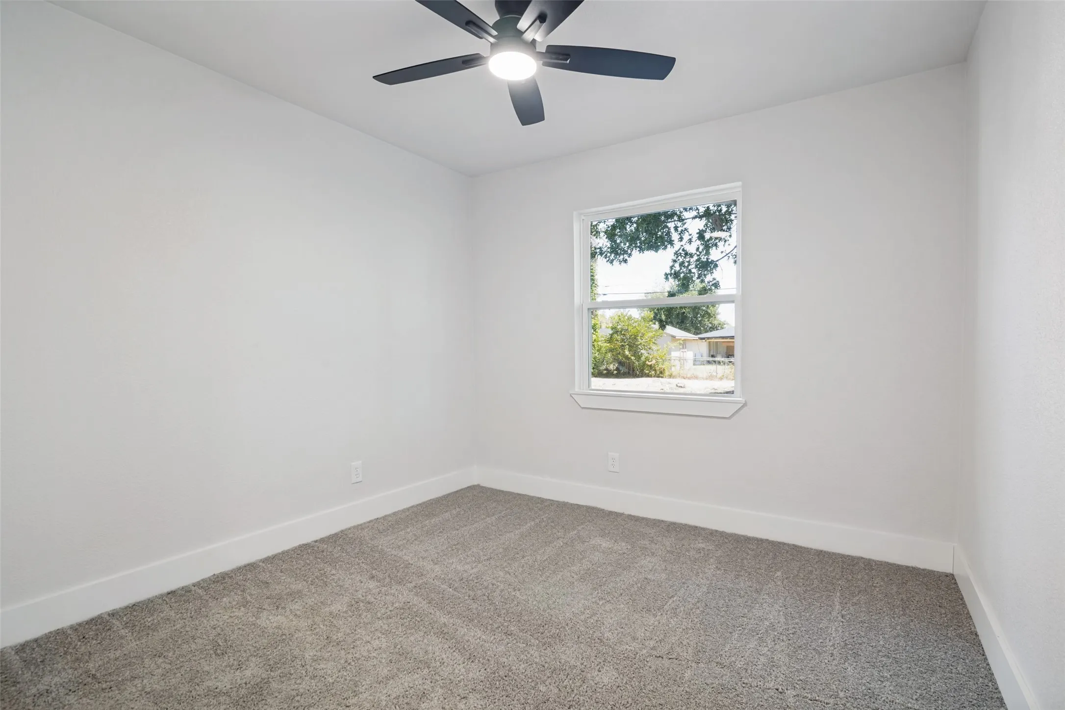 Neutral-toned carpeting, white walls, and a ceiling fan with integrated lighting