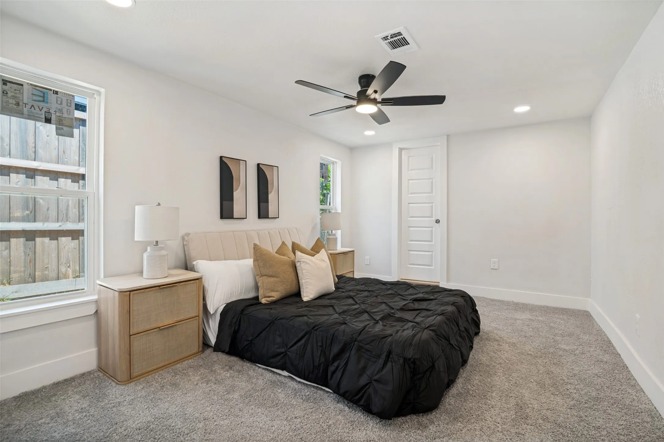 Recessed lighting, ceiling fan with integrated light, multiple windows, white paneled door, and neutral-tone carpeting