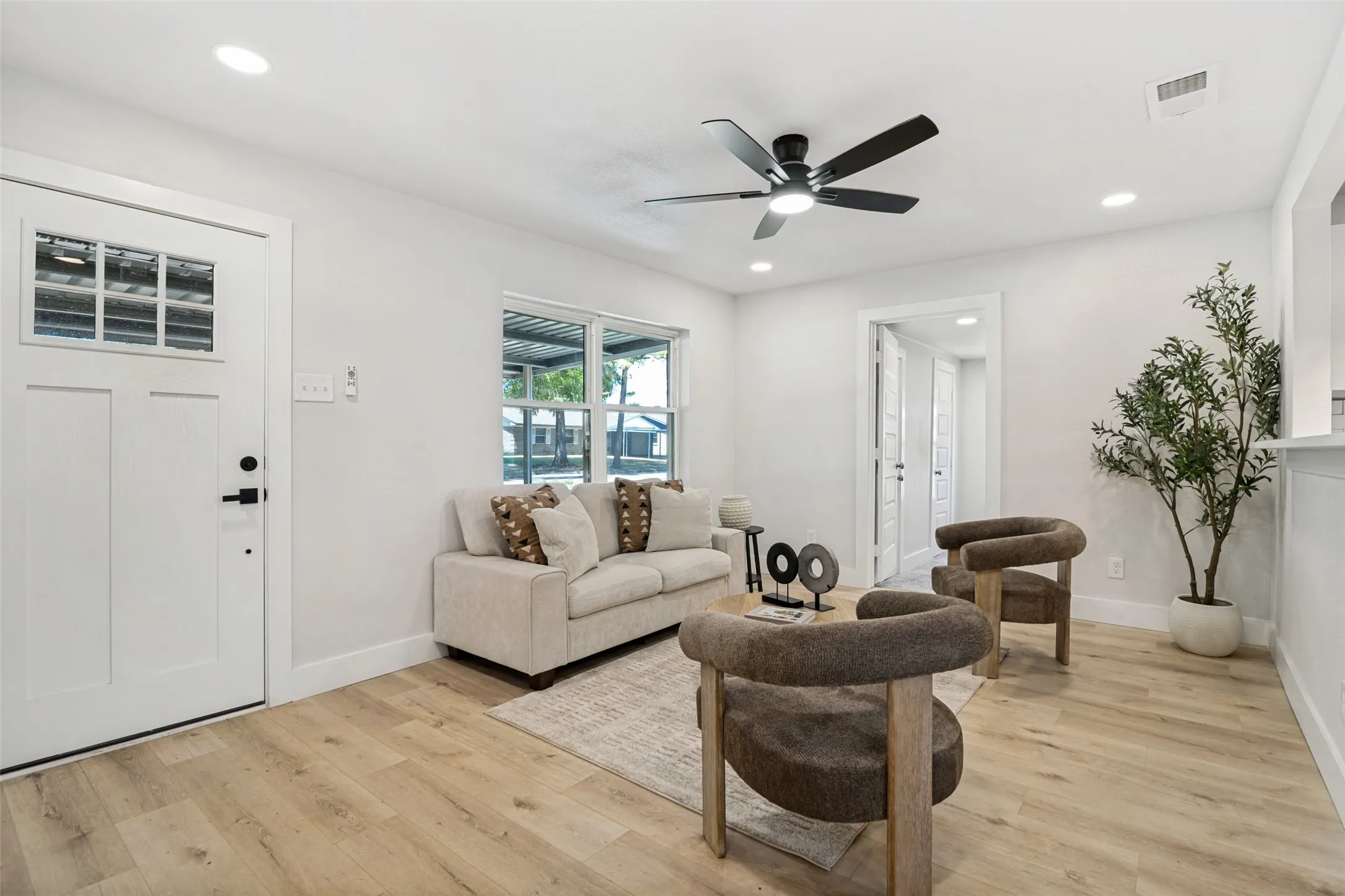Bright living space featuring recessed lighting, a ceiling fan, and wood-finish flooring