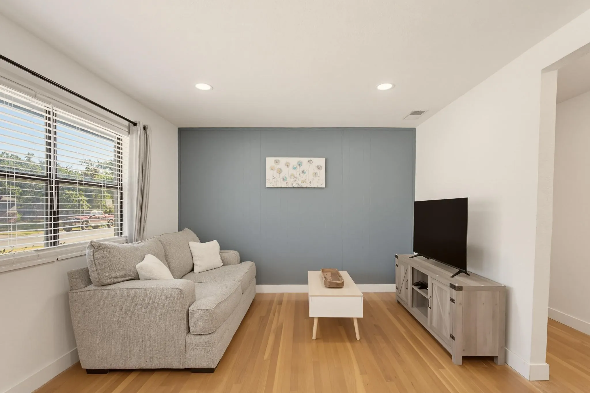 Bright natural light beams through expansive windows onto beautiful hardwood floors. The front door includes a secure glass storm door for extra light, and a convenient built-in mail slot allows for direct home delivery.