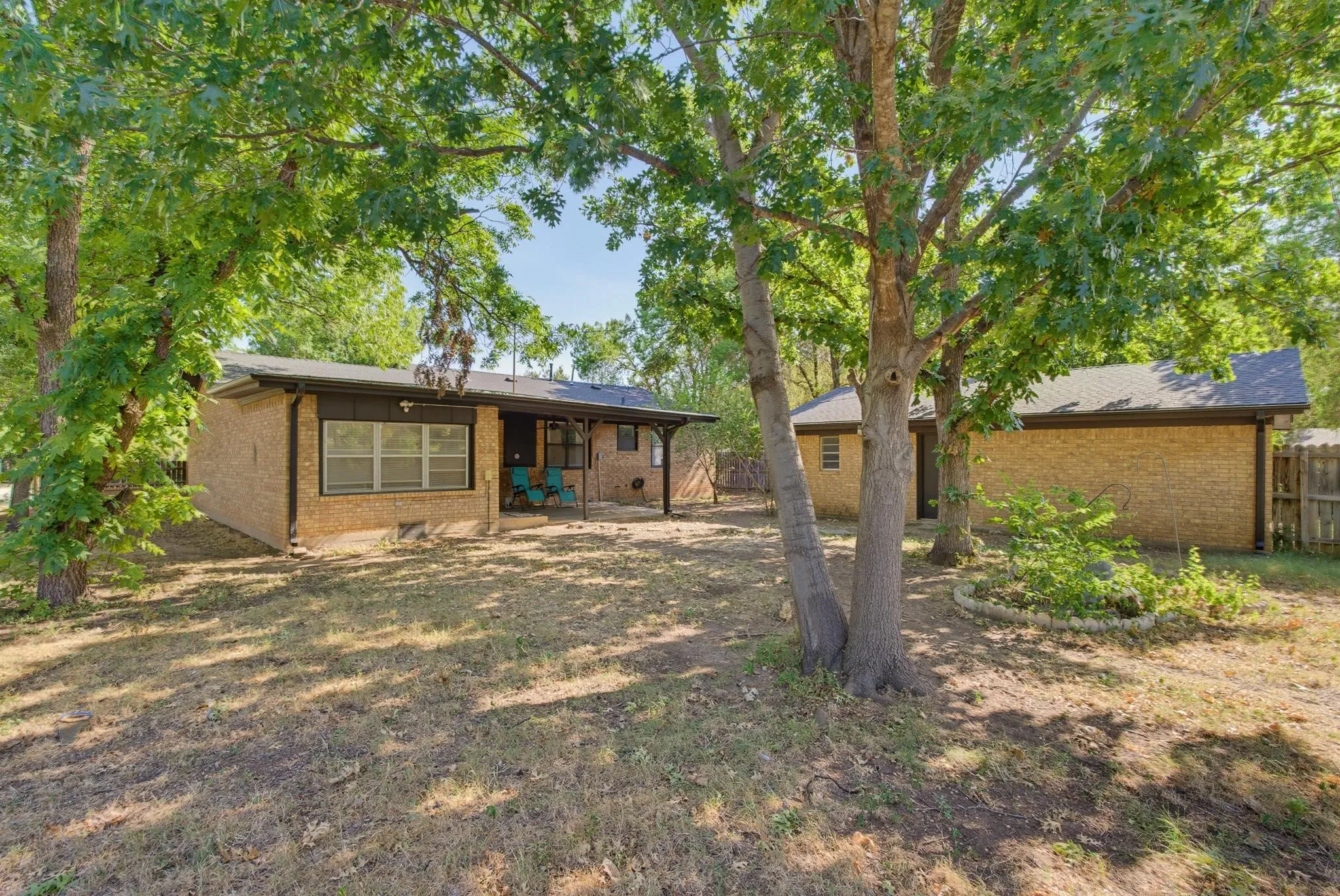 Nice shade trees in backyard. View of detached, 2 car garage with alley access.