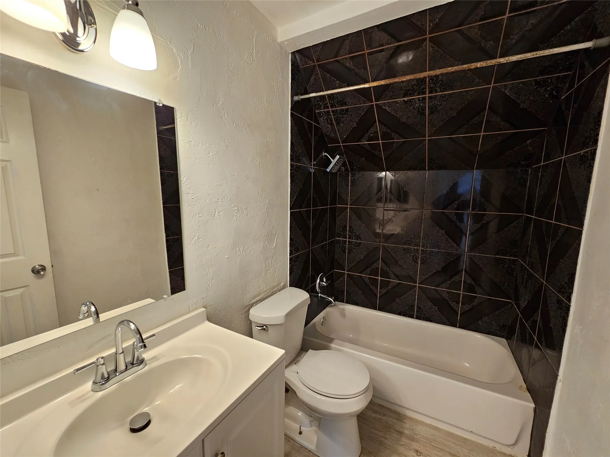 White vanity with integrated sink, chrome faucet, and rectangular mirror