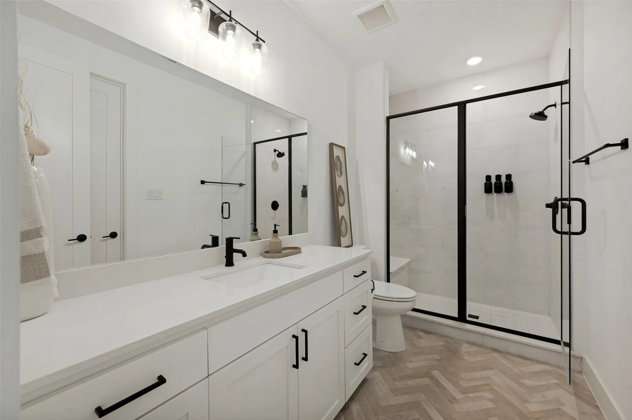 Double vanity with a white countertop and undermount sink, matte black faucet, and white cabinetry