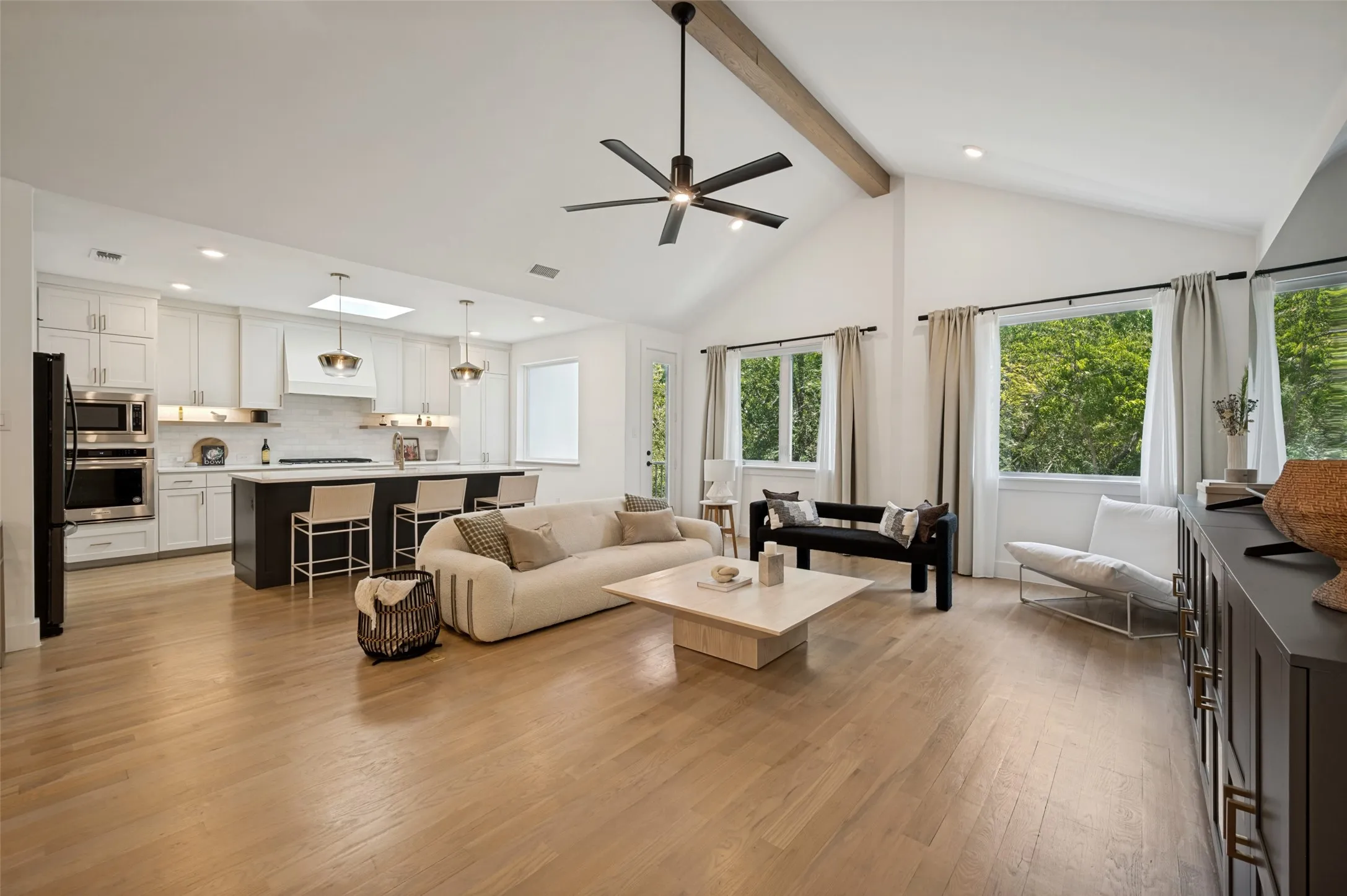 Vaulted ceiling with exposed wood beam, wood-finish flooring, recessed lighting, and kitchen island with built-in cabinetry