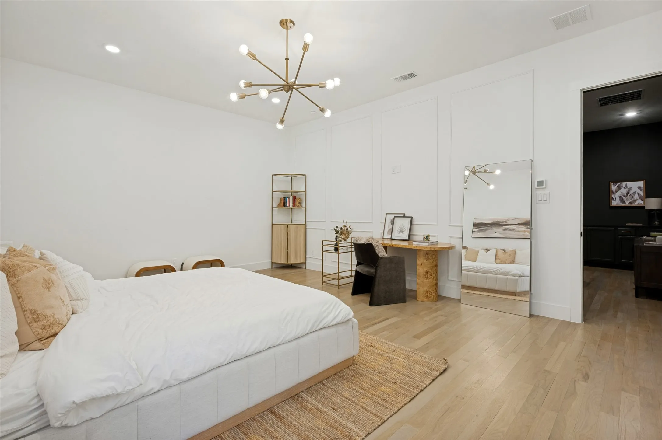 Spacious room featuring light wood-finish flooring, a contemporary sputnik chandelier, and decorative wall molding