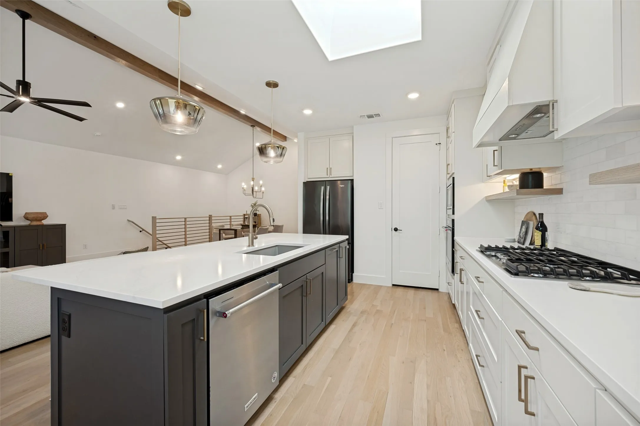 Kitchen featuring a center island, white countertops, stainless steel appliances, and wood-finish flooring