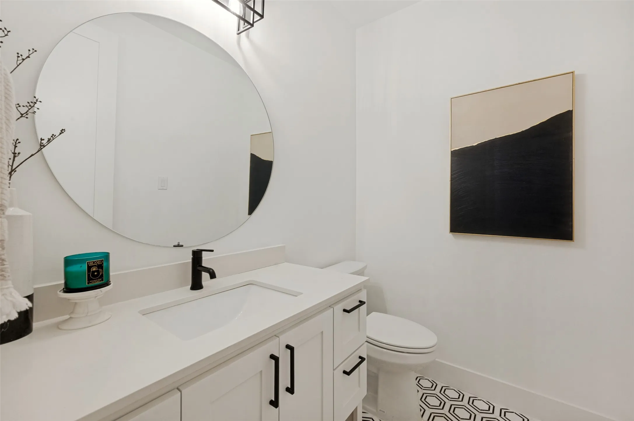 White vanity with shaker-style cabinetry, matte black hardware, integrated rectangular sink, and single-handle faucet
