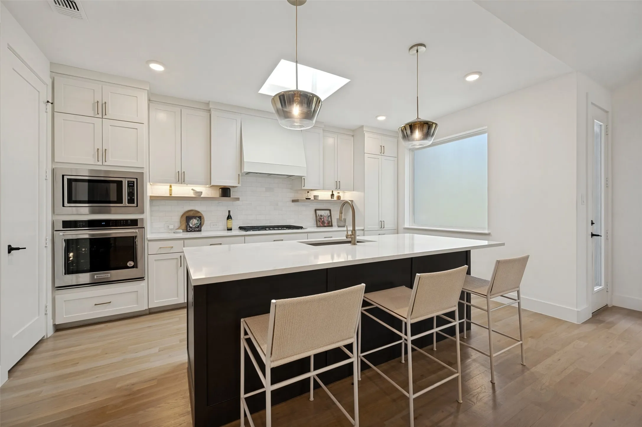 Kitchen featuring a central island with countertop, stainless steel appliances, recessed lighting, and wood-finish flooring