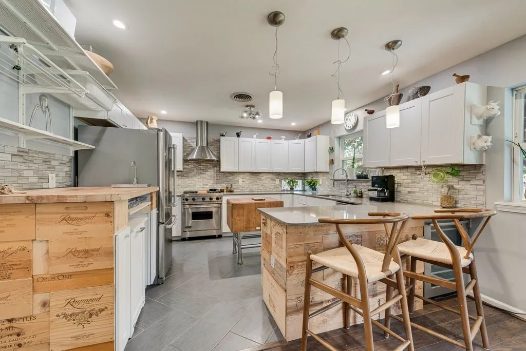 Updated kitchen has ample storage, a breakfast bar, stainless steel appliances and a wine fridge.