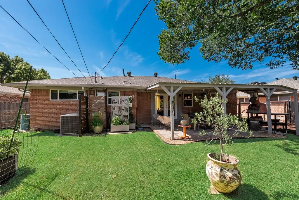 This backyard was built to host get-togethers - covered patio, pizza oven and room for pets and kids to play.