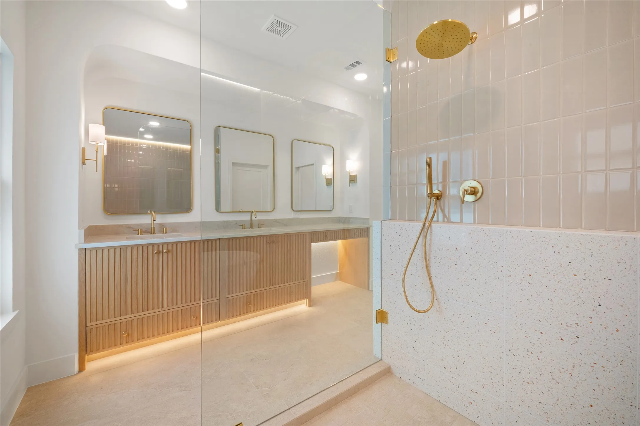 Dual vanity with separate sinks, fluted wood-finish cabinetry, and quartz countertops