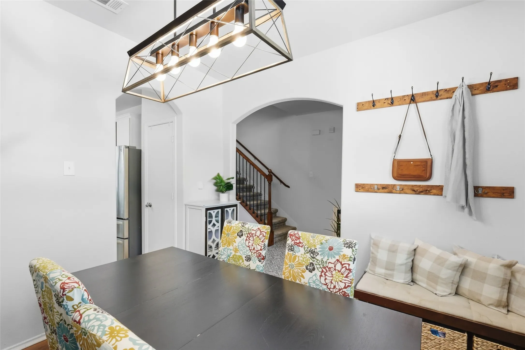 Dining area featuring a linear chandelier with a metal frame and exposed bulbs