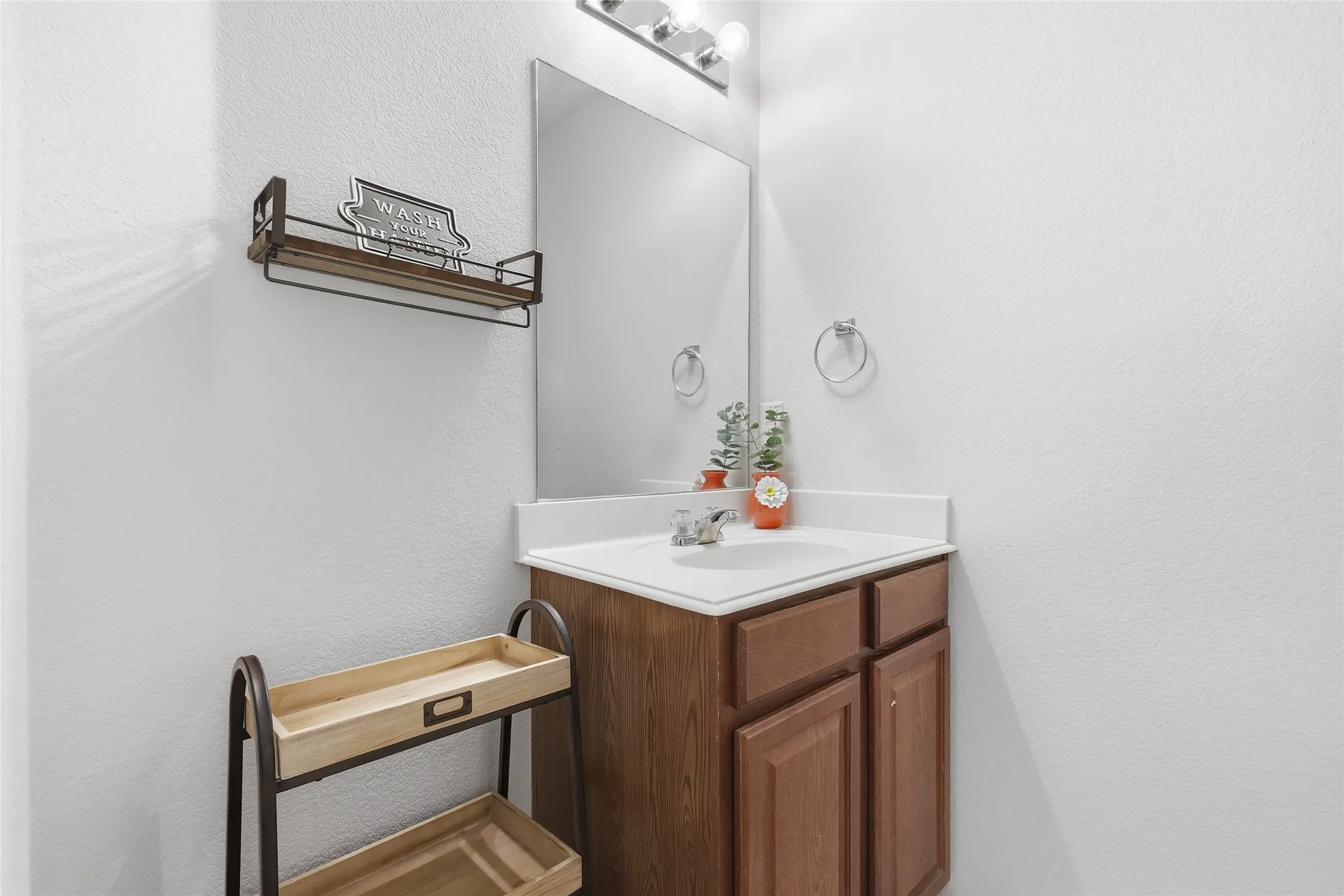 Bathroom vanity featuring a white countertop with an integrated sink and a chrome faucet