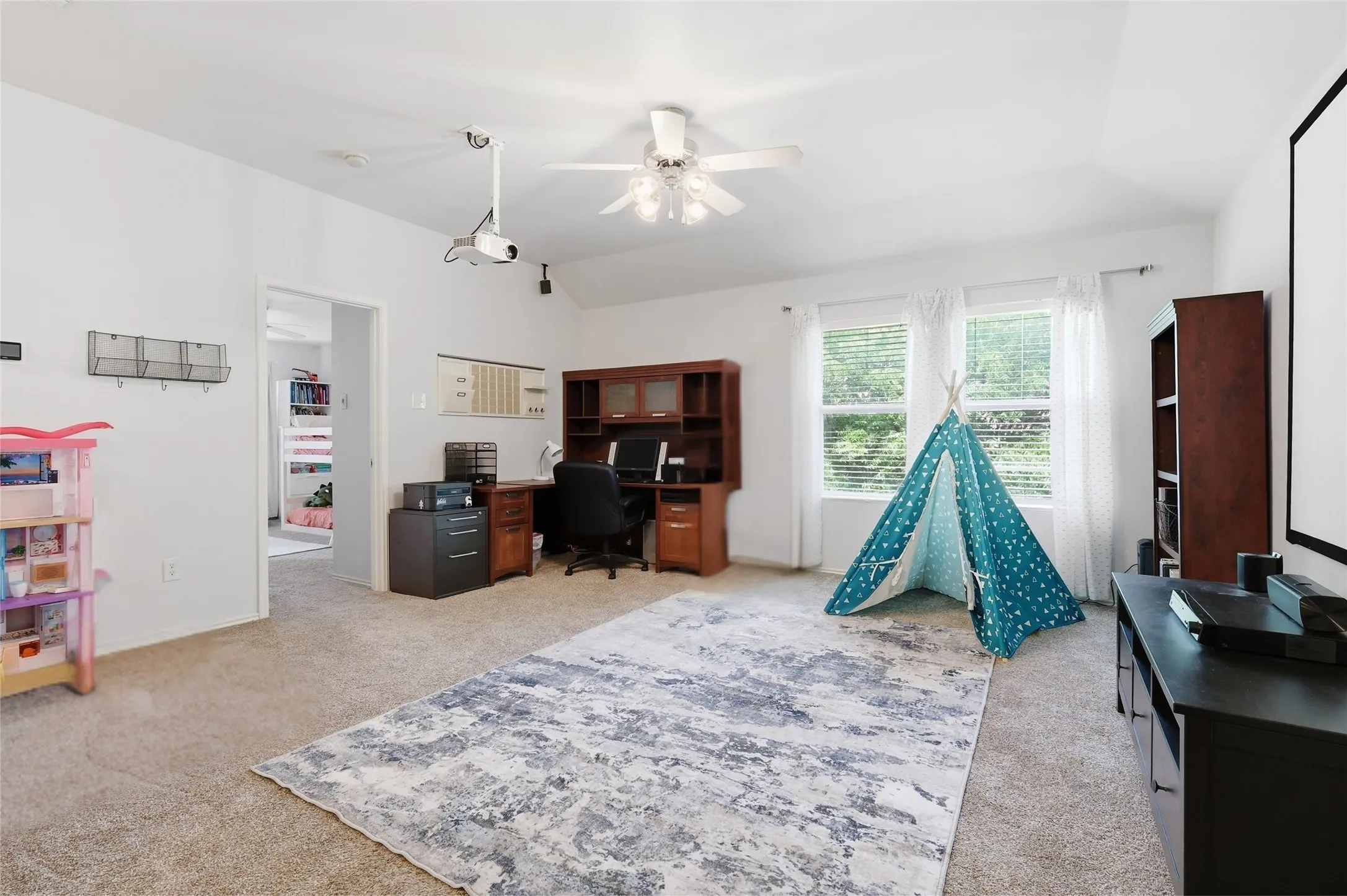 Carpeted room featuring a ceiling fan, recessed lighting, and ample natural light from multiple windows