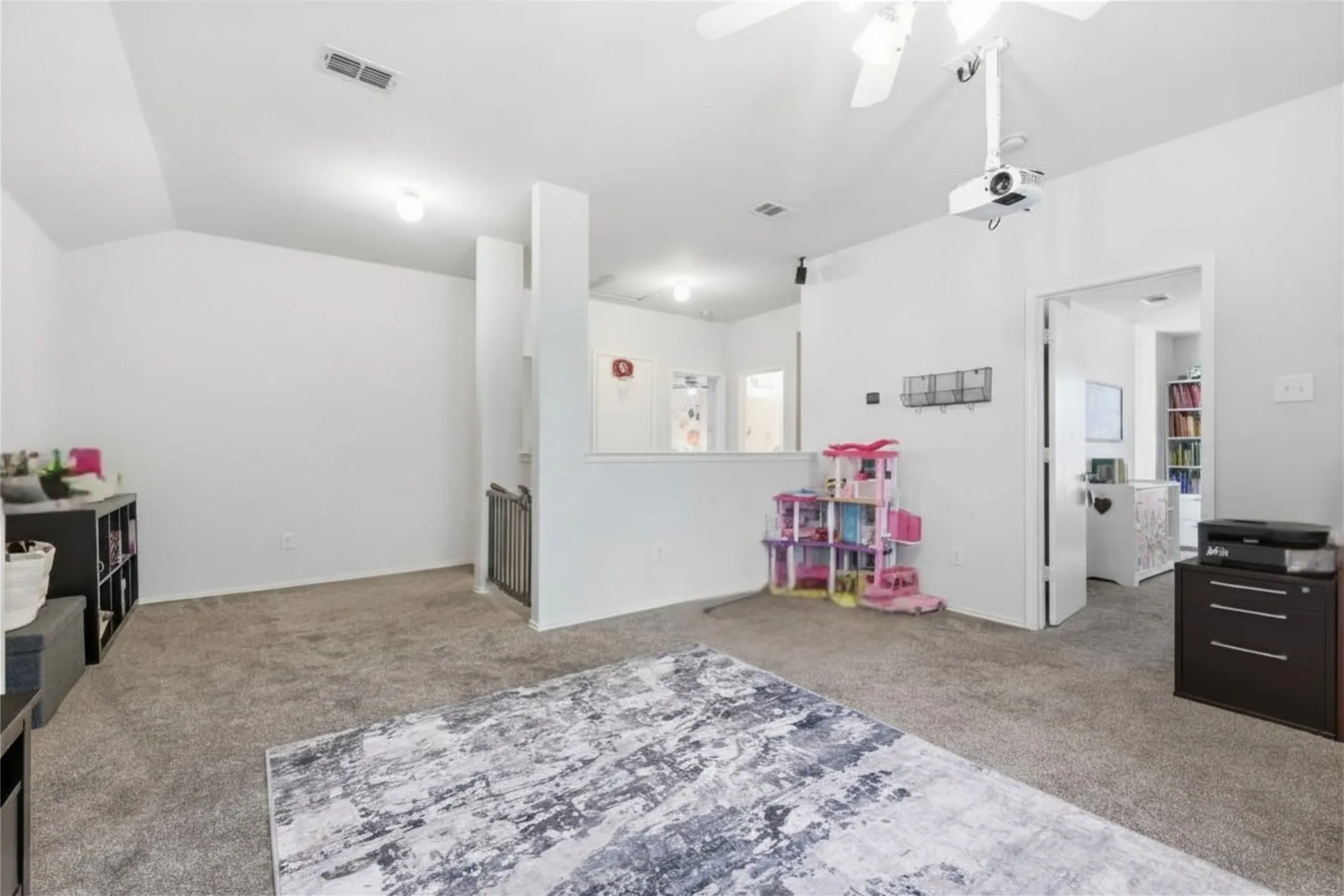 Carpeted upper-level landing featuring a ceiling fan with integrated lighting, recessed lighting, and a built-in projector