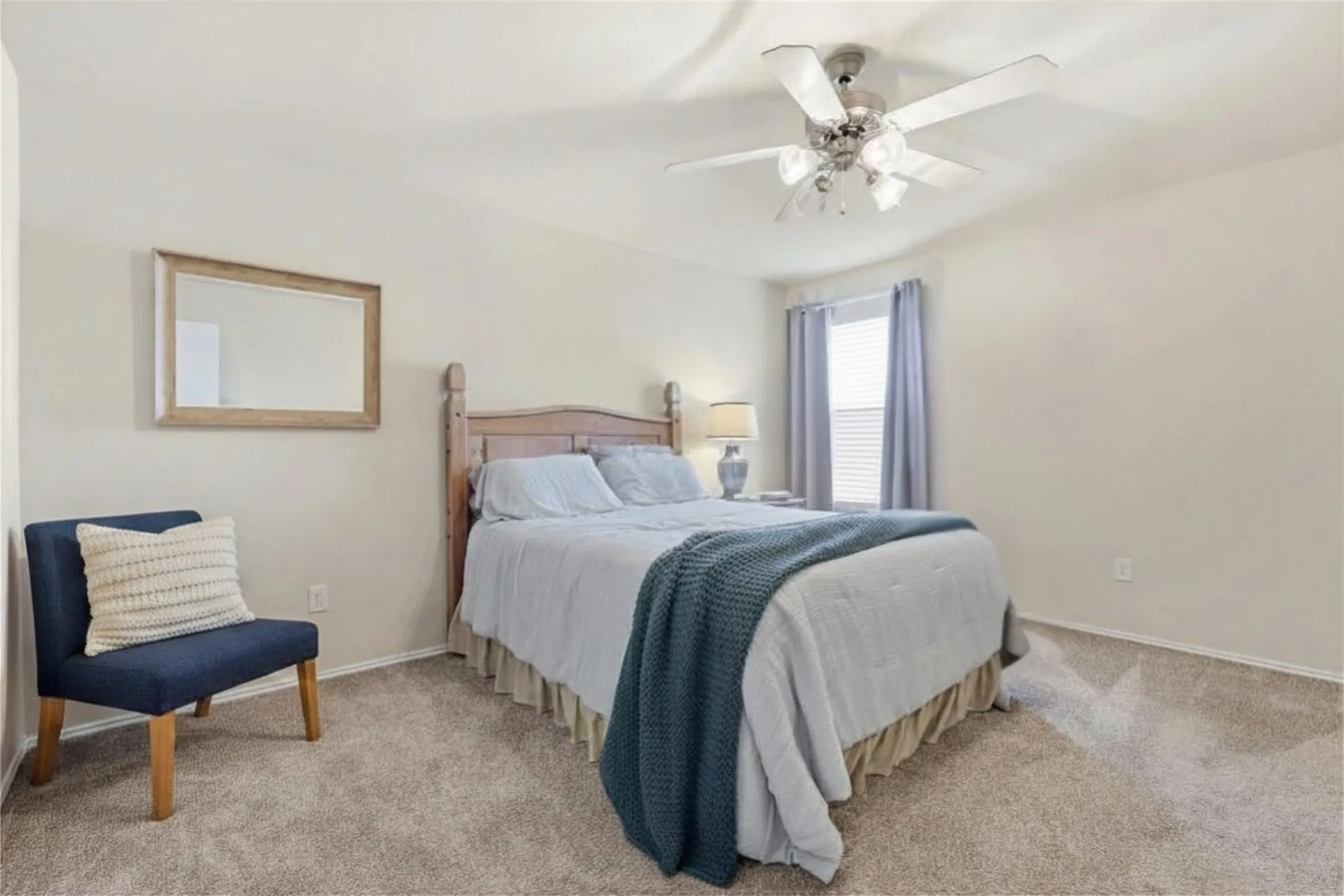 Carpeted room featuring a ceiling fan with integrated lighting, a window with blinds and drapery, and neutral-toned walls