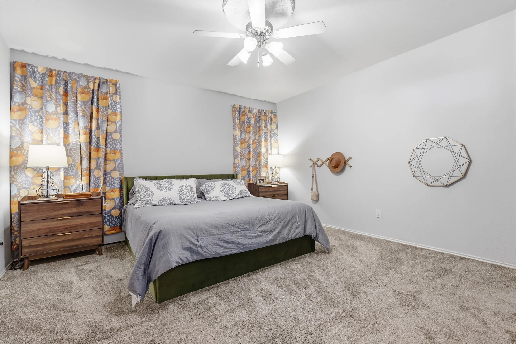 Spacious room featuring light gray wall paint and soft carpet flooring