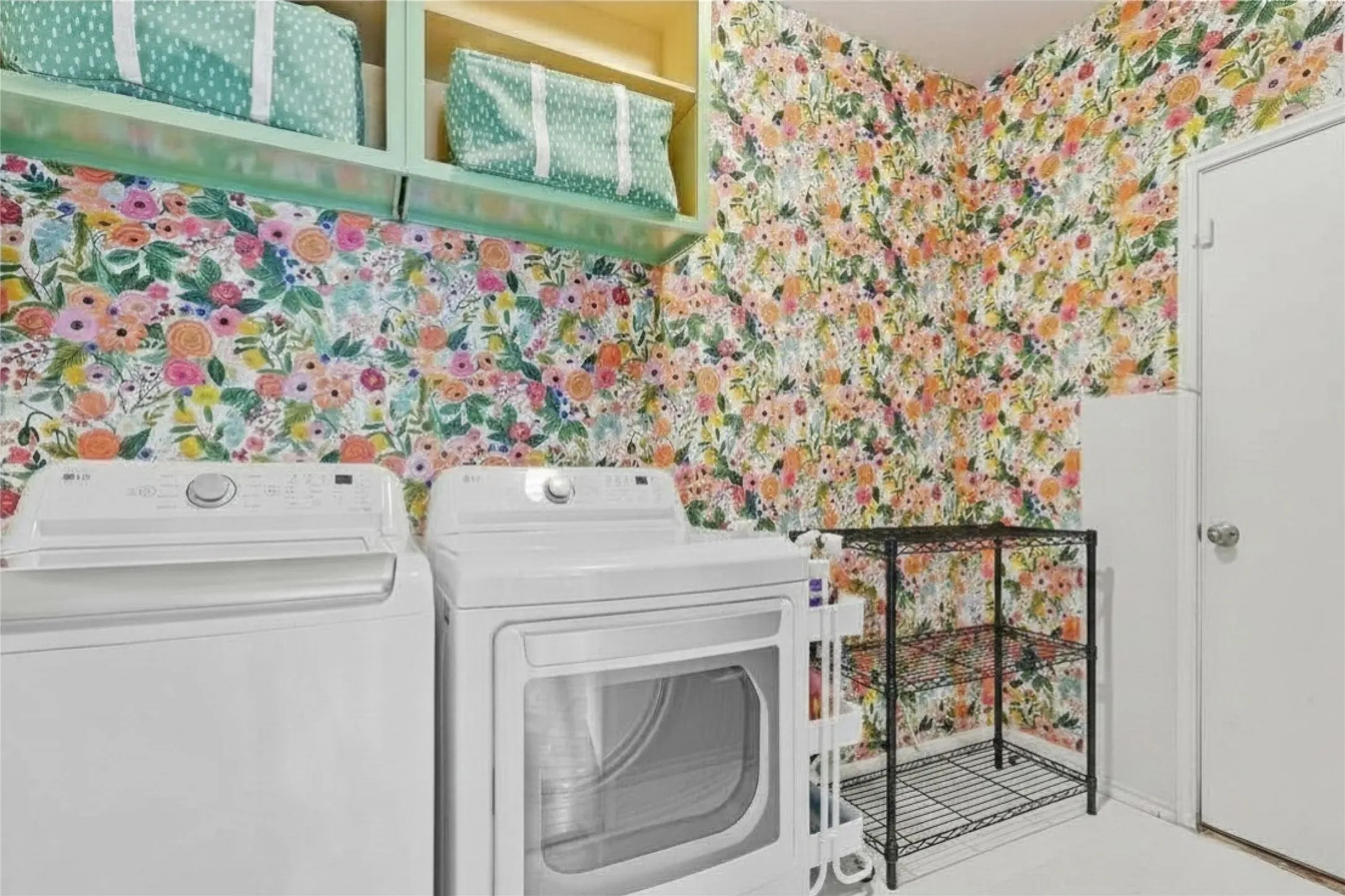 Utility area featuring vibrant floral wallpaper