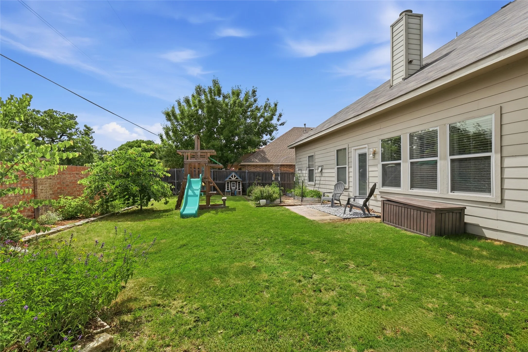 Expansive green lawn with mature trees and perimeter landscaping