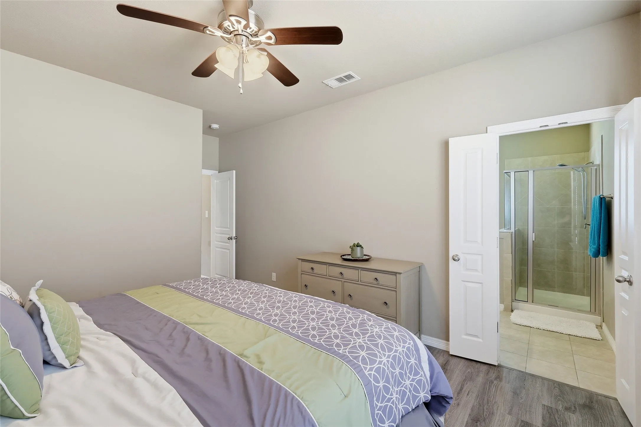 Bedroom featuring wood-finish flooring, a ceiling fan with integrated lighting, and a neutral wall color