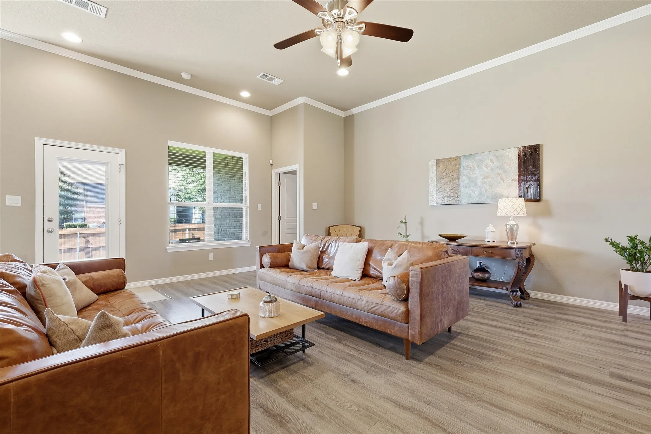 Spacious living area featuring high ceilings, wood-finish flooring, recessed lighting, and a ceiling fan