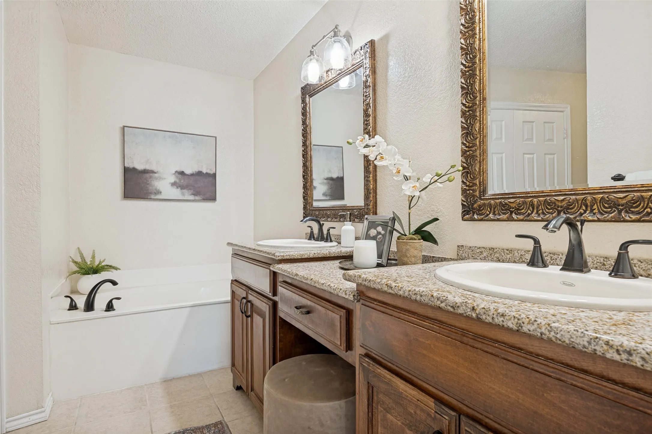 Dual vanity with granite-style countertops, under-mount sinks, and oil-rubbed bronze fixtures