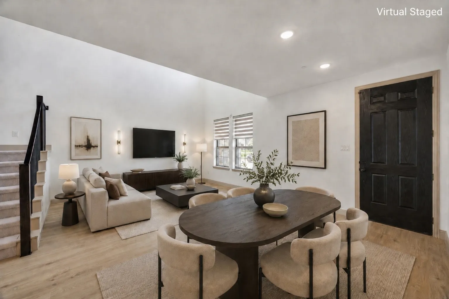 Virtual Staged - Vaulted ceilings enhance this open-concept room and a paneled entry door