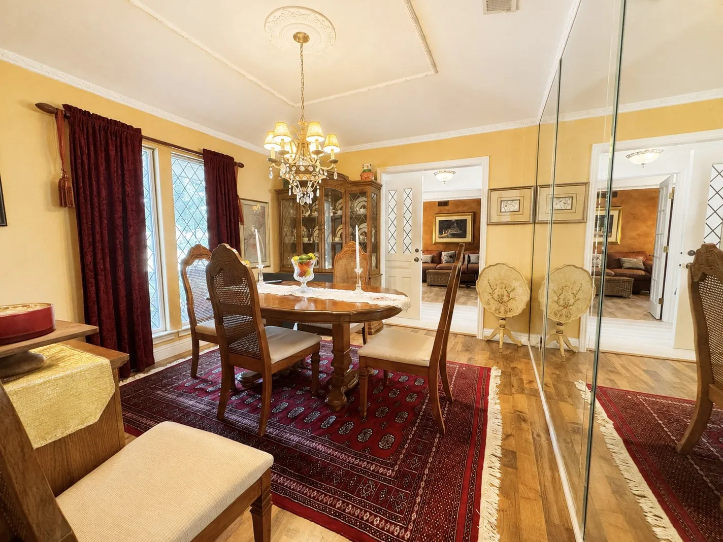 Recessed ceiling with decorative medallion, chandelier lighting, and hardwood flooring
