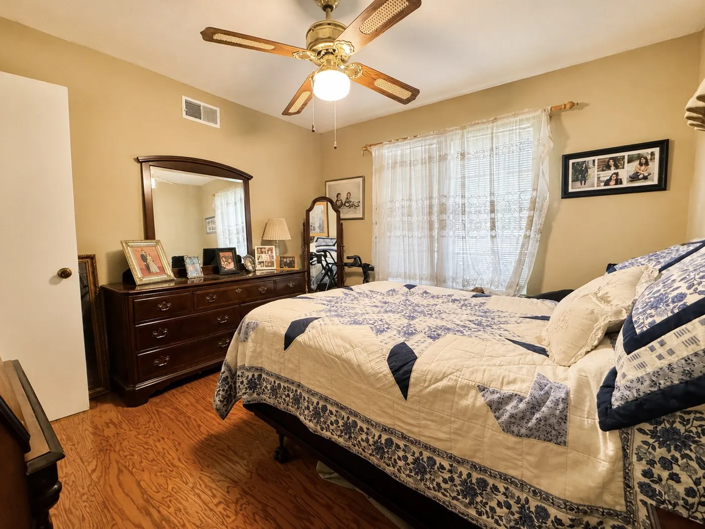 Wood-finish flooring, ceiling fan with integrated lighting, natural light from a window, and neutral wall tones