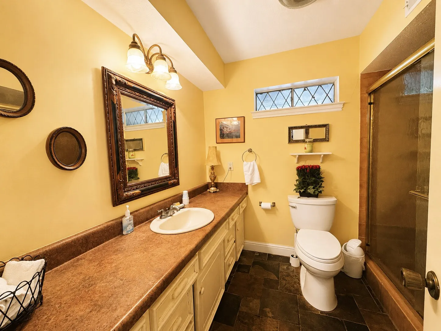 Vanity with integrated sink, patterned countertop, and decorative framed mirror