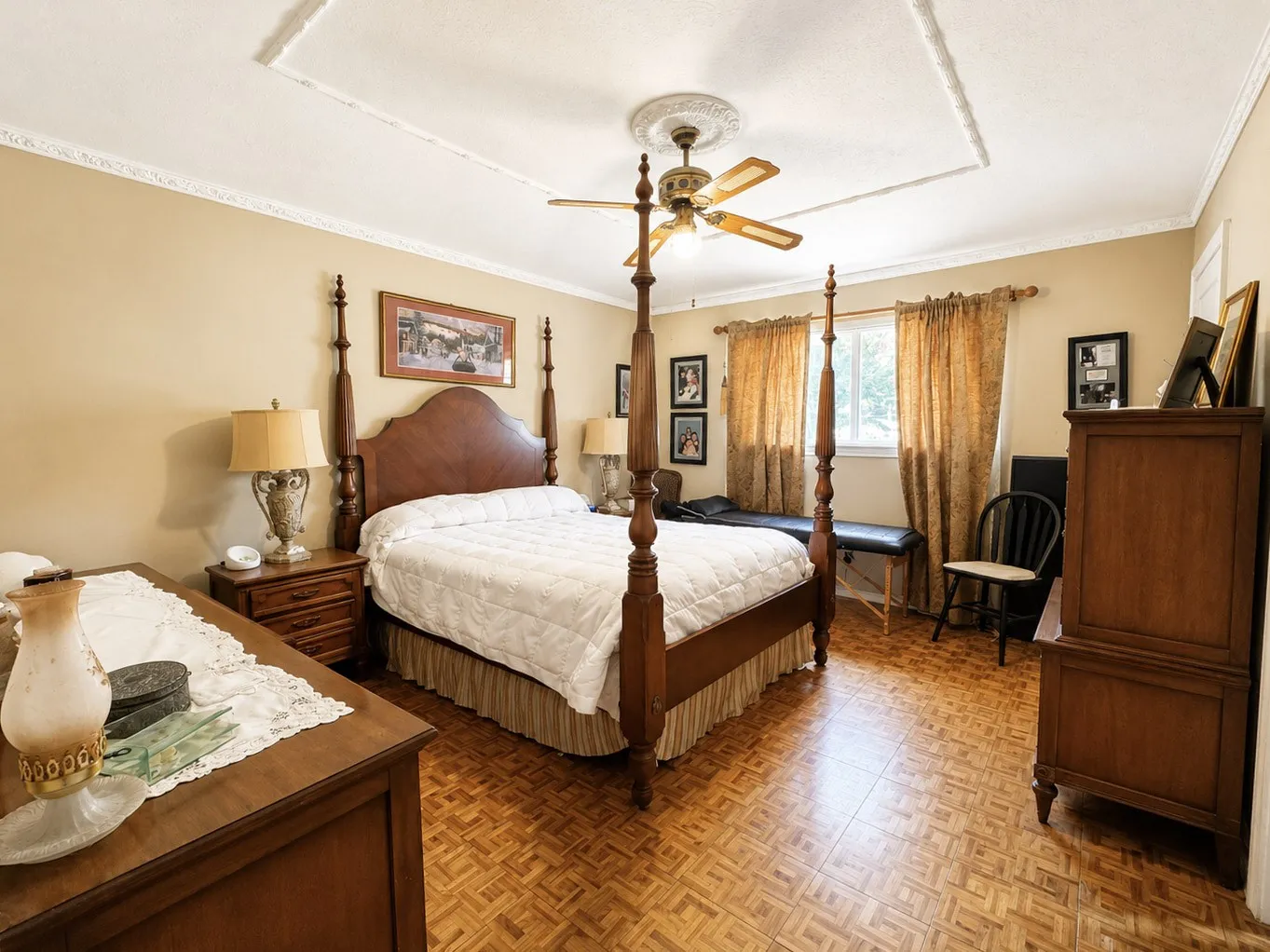 Tray ceiling with decorative molding, ceiling fan, and wood-finish flooring