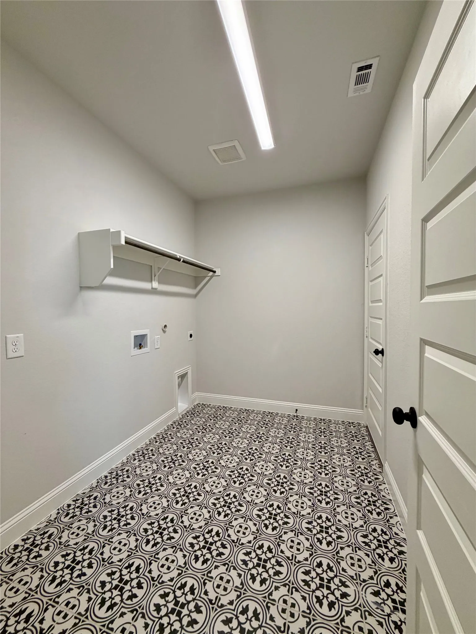 Whimsical laundry room with decorative tile and a dedicated plug for 2nd fridge or freezer