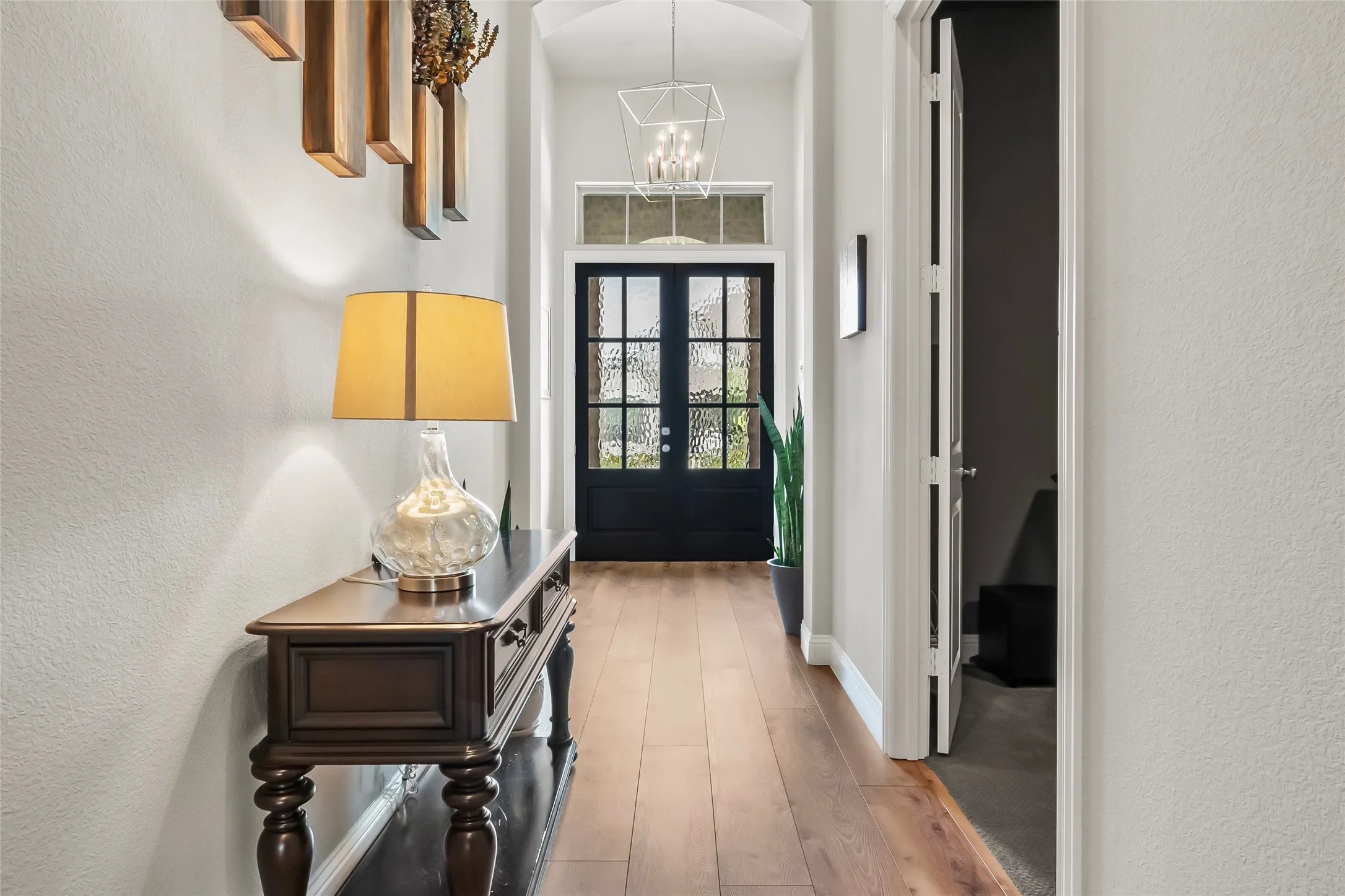Doorway to outside with a chandelier, french doors, and light hardwood / wood-style floors