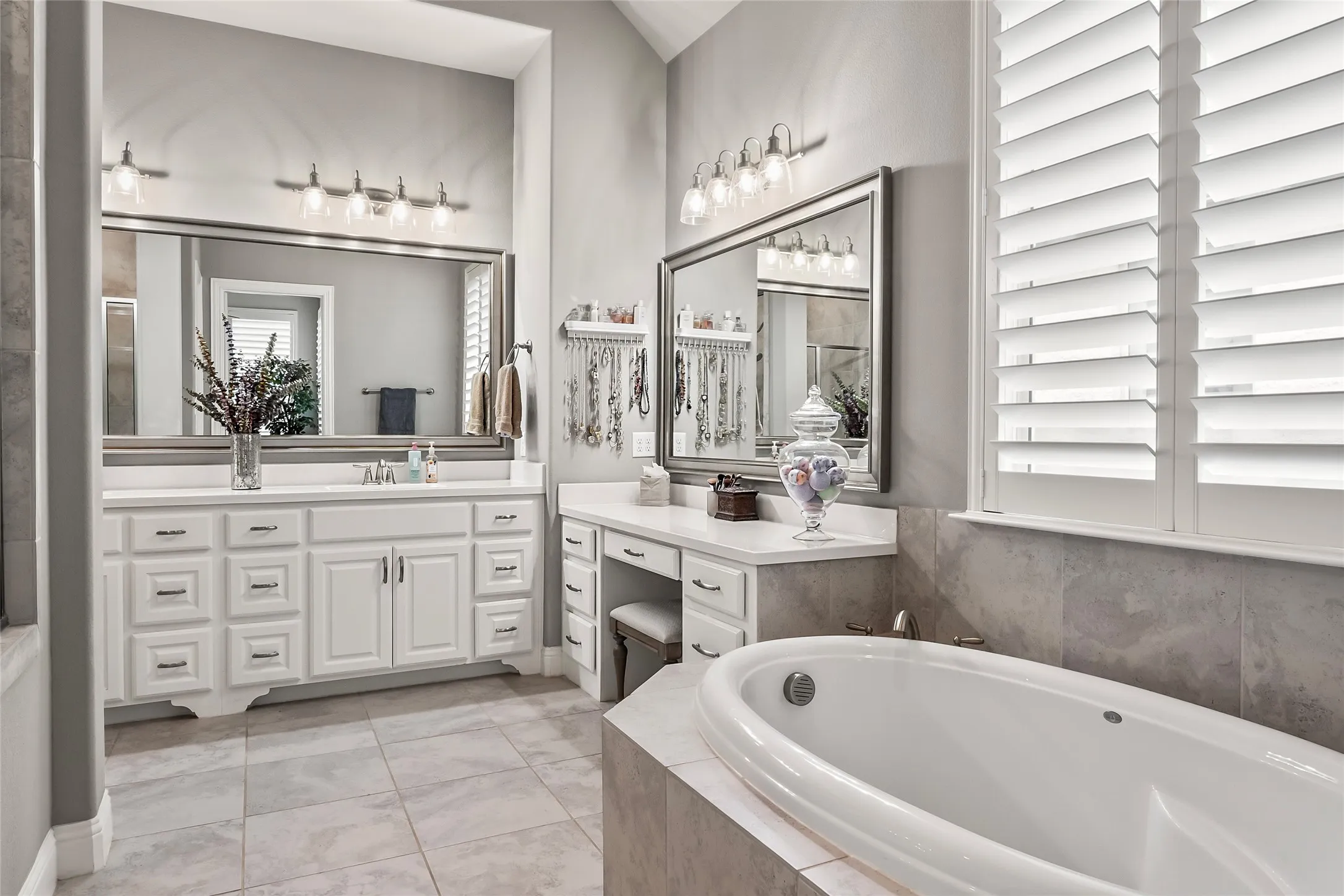 Bathroom featuring tile patterned floors, vanity, and tiled bath