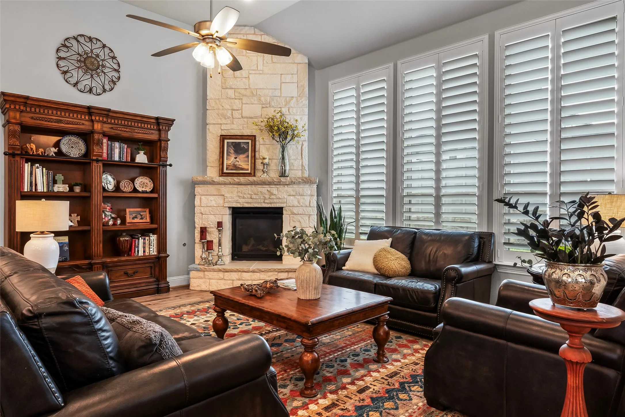 Living room featuring a fireplace, a healthy amount of sunlight, ceiling fan, and lofted ceiling