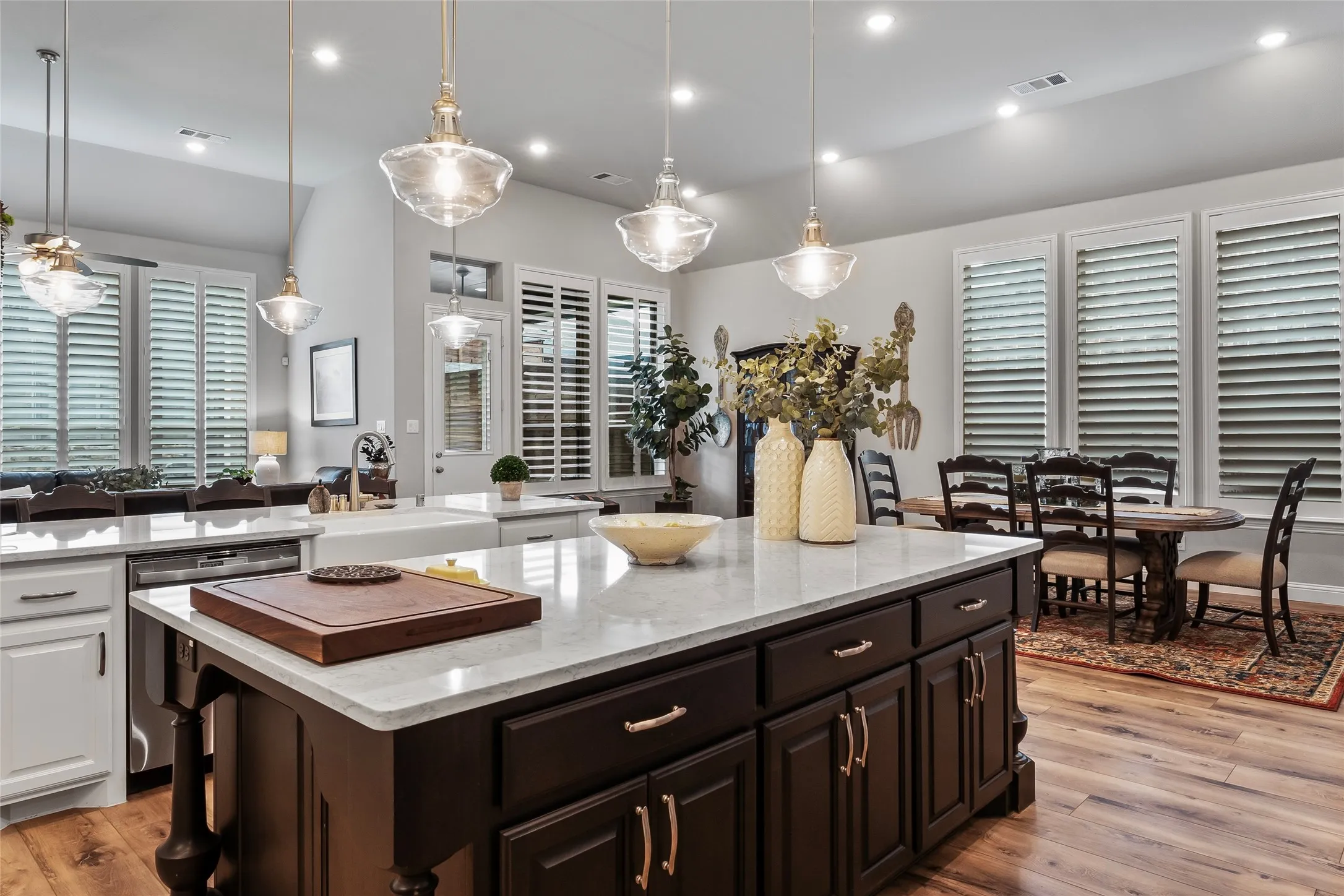 Kitchen featuring white cabinets, a center island, light hardwood / wood-style floors, and sink