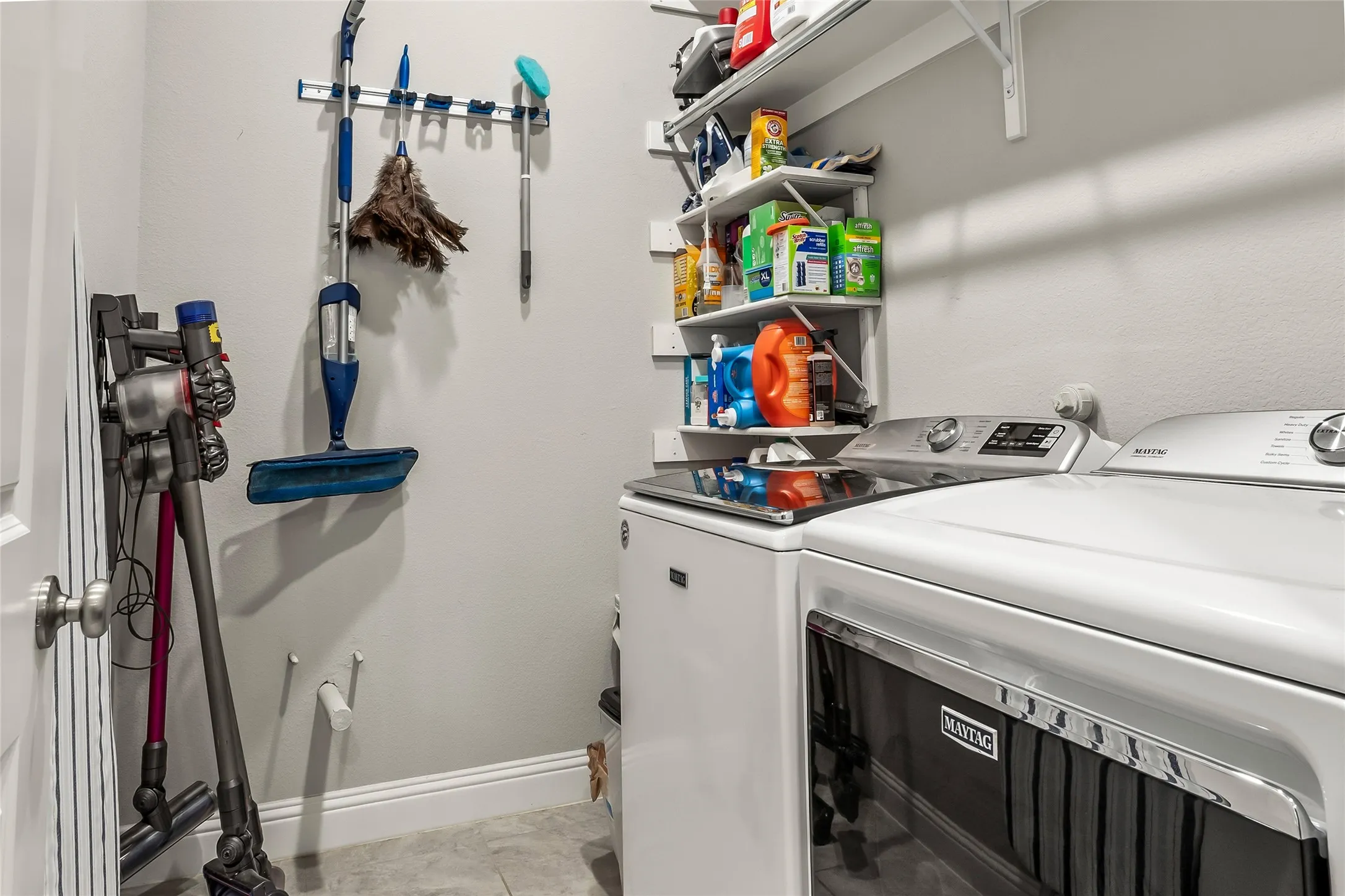 Washroom featuring light tile patterned floors and washing machine and clothes dryer
