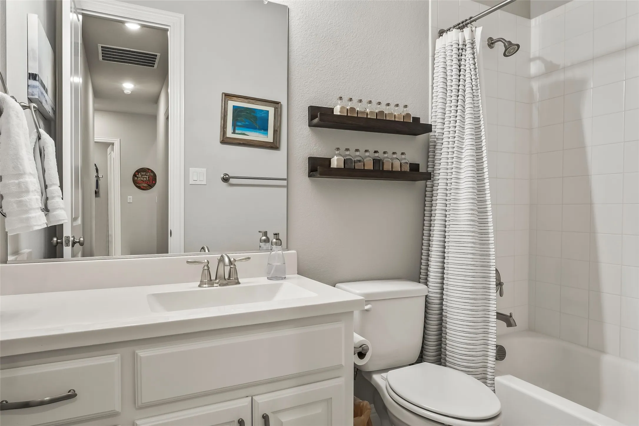 Full bathroom featuring shower / bath combo, vanity, and toilet
