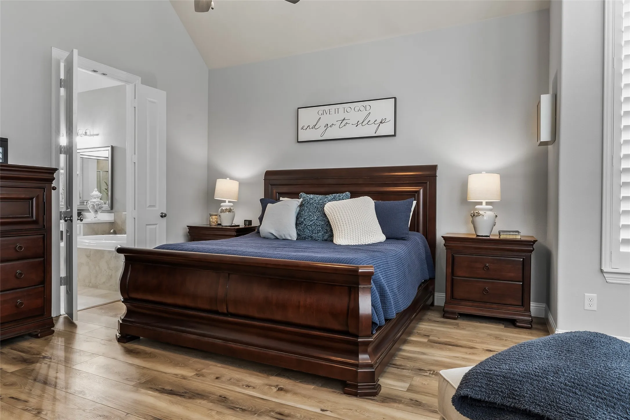 Bedroom featuring connected bathroom, ceiling fan, light hardwood / wood-style floors, and vaulted ceiling