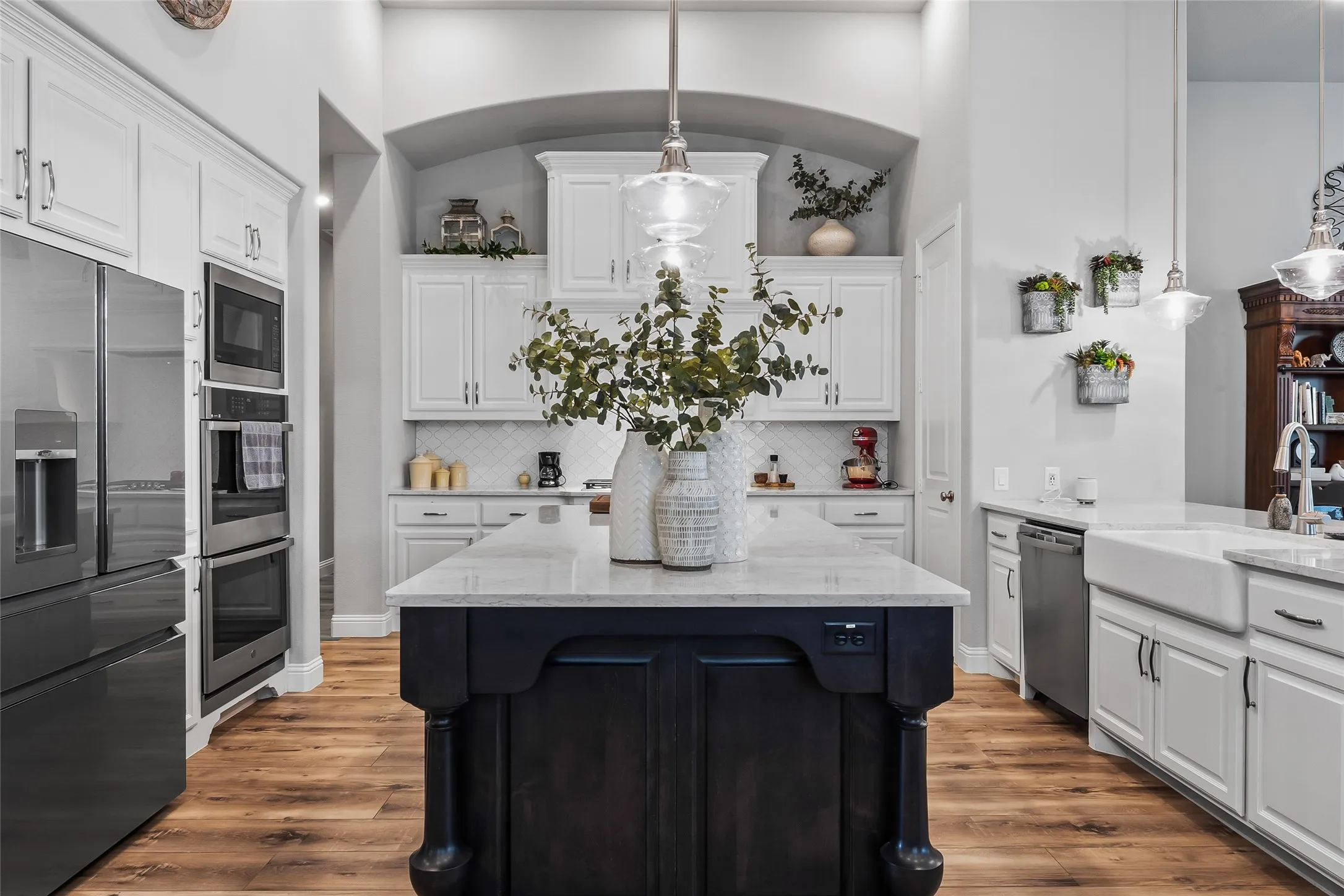 Kitchen with white cabinets, stainless steel appliances, and hanging light fixtures