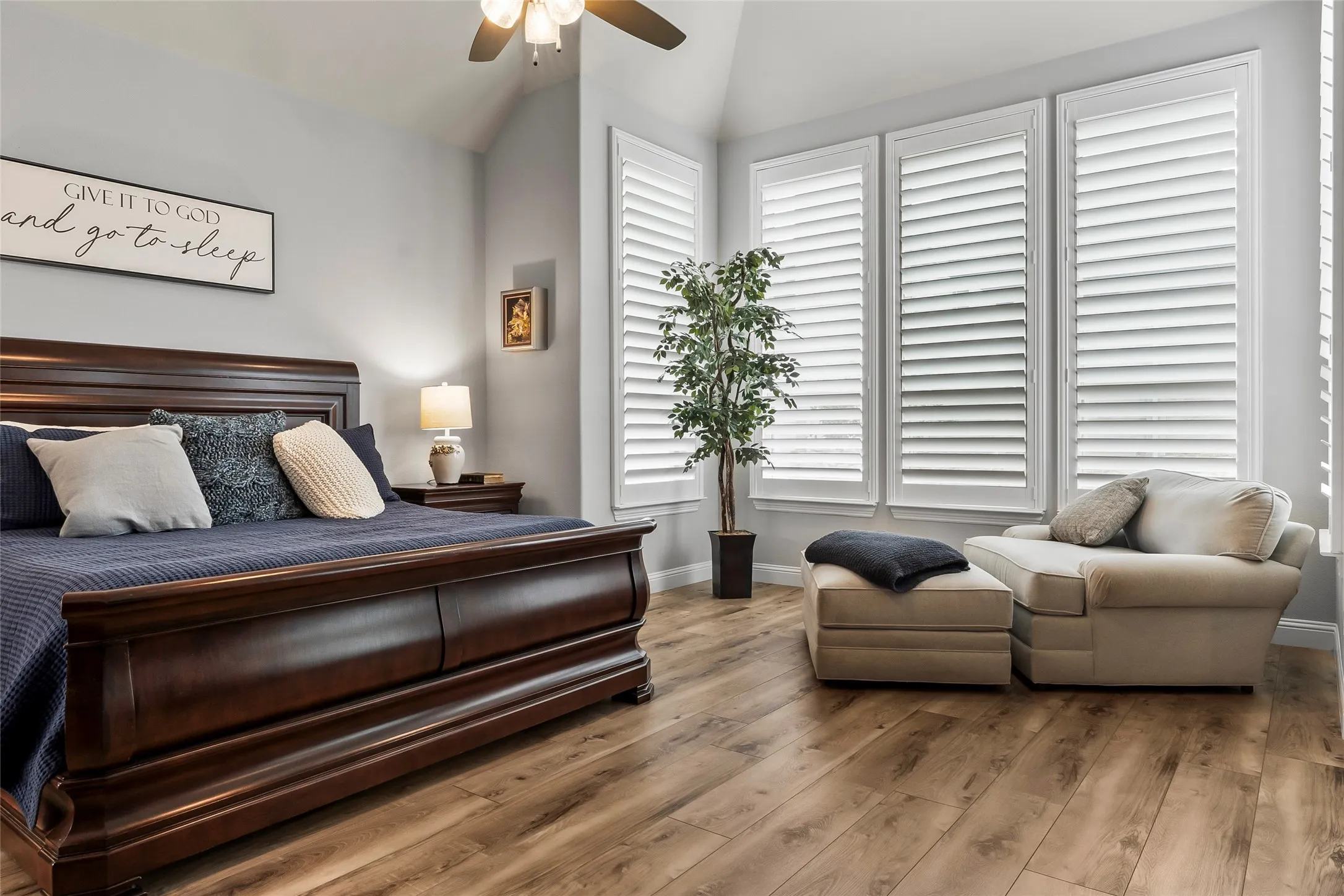 Bedroom with hardwood / wood-style floors, ceiling fan, and lofted ceiling